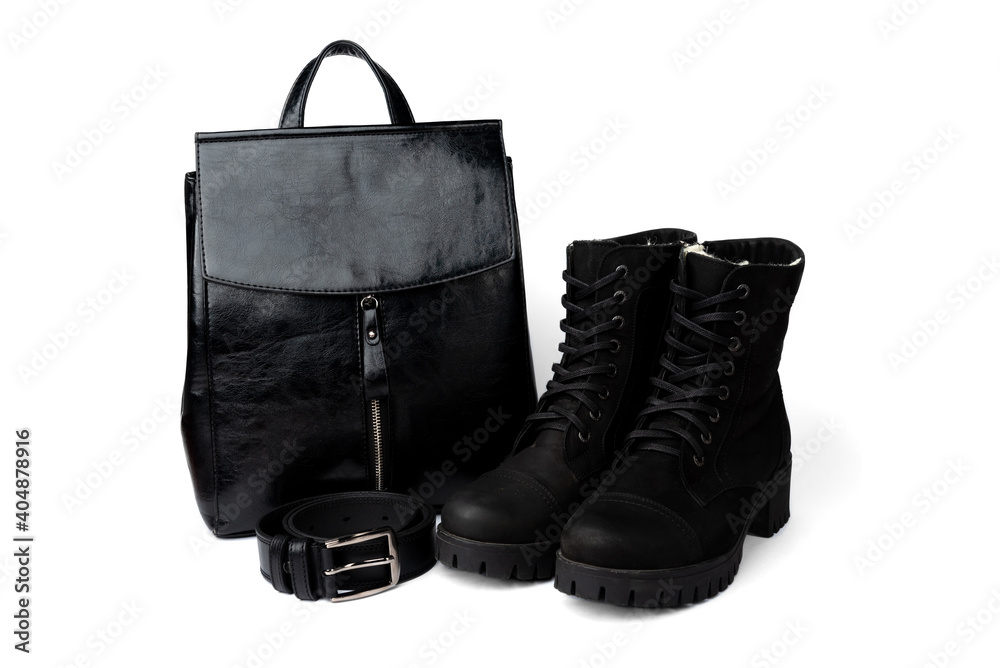 Black winter boots, leather belt and backpack isolated on white background.