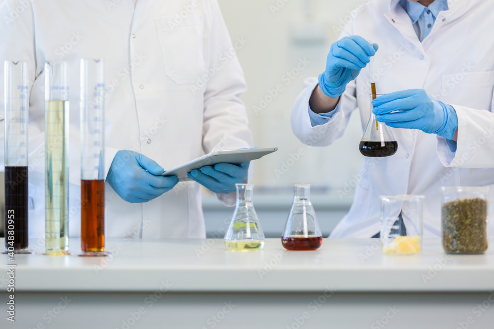 Scientist’s hands working with tablet in cbd laboratory Scientist’s hands working with tablet in cbd laboratory