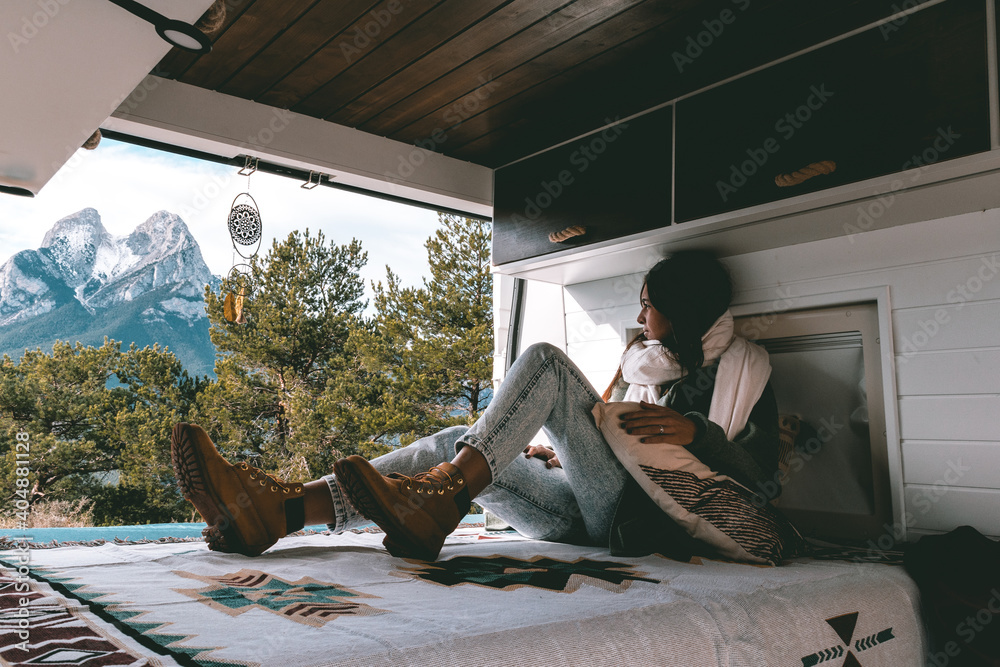 Ταπετσαρία image of a young brunette woman, stretched out inside a camper van, looking towa