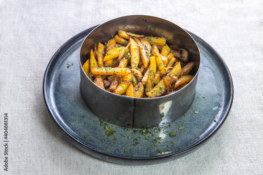 French fries sprinkled with herbs in a metal cup top view. French fries sprinkled with herbs in a metal cup top view.