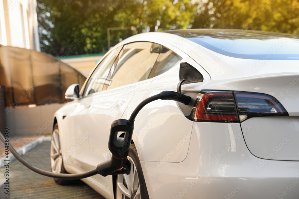 Charging modern electric car from station outdoors Charging modern electric car from station outdoors