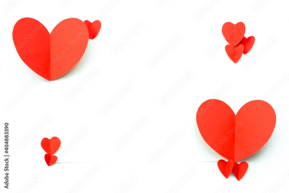 Valentine's Day background. Red paper hearts are laid out in four dots on a white background with space for text. Bright colorful hearts for postcards.