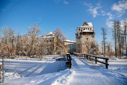 Medieval renaissance water castle with half-timbered tower with snow in winter sunny day, Historic Romantic chateau Blatna near Strakonice in southern Bohemia, Czech Republic