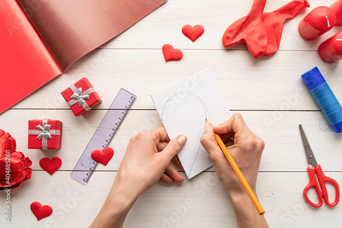 Step by step instruction making paper heart shape hot air balloon. Step 1 - fold paper and draw a half of a heart