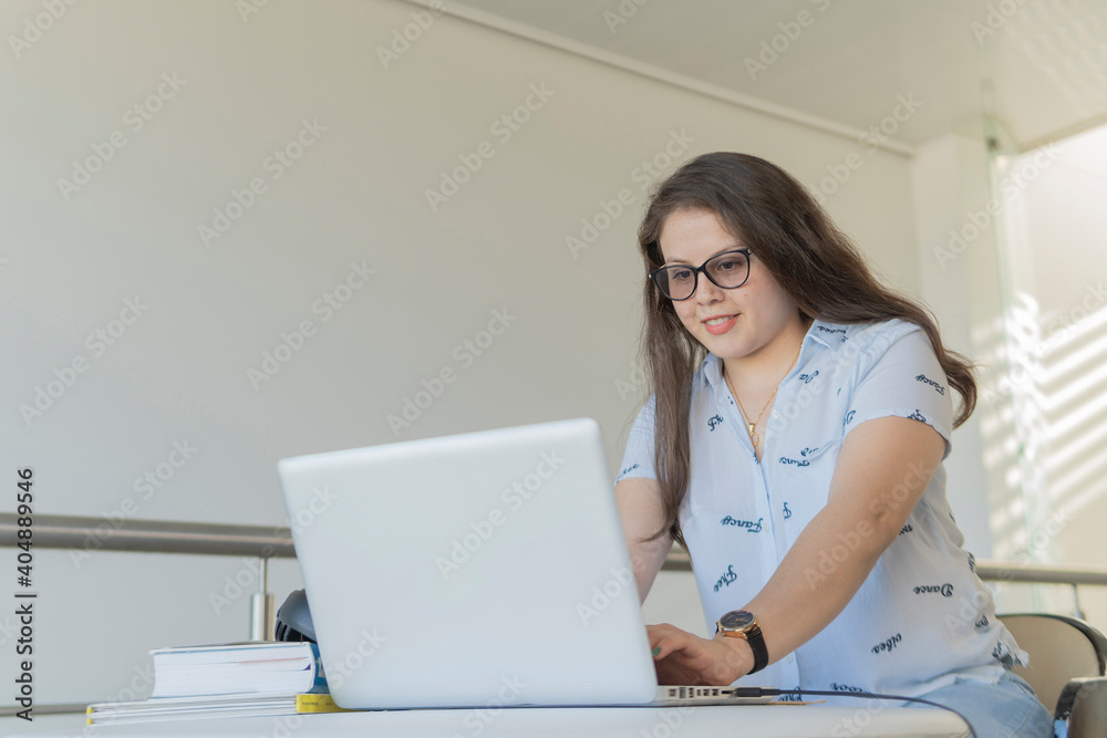Mujer concentrada y feliz mientras trabaja con su computadora. Concepto trabajo y estudio en casa Mujer concentrada y feliz mientras trabaja con su computadora. Concepto trabajo y estudio en casa