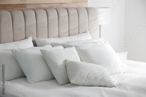 Comfortable bed with soft white pillows indoors