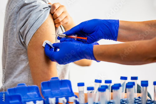 Health care and medical prevention. Hands of doctor in blue glove injecting coronavirus covid-19 vaccine.