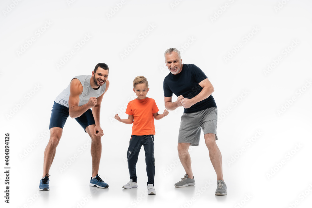 boy with dad and grandfather in sportswear demonstrating strength while smiling at camera on white boy with dad and grandfather in sportswear demonstrating strength while smiling at camera on white