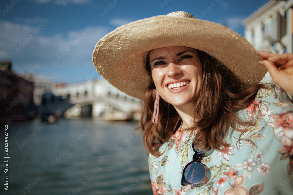 happy elegant traveller woman in floral dress with sunglasses