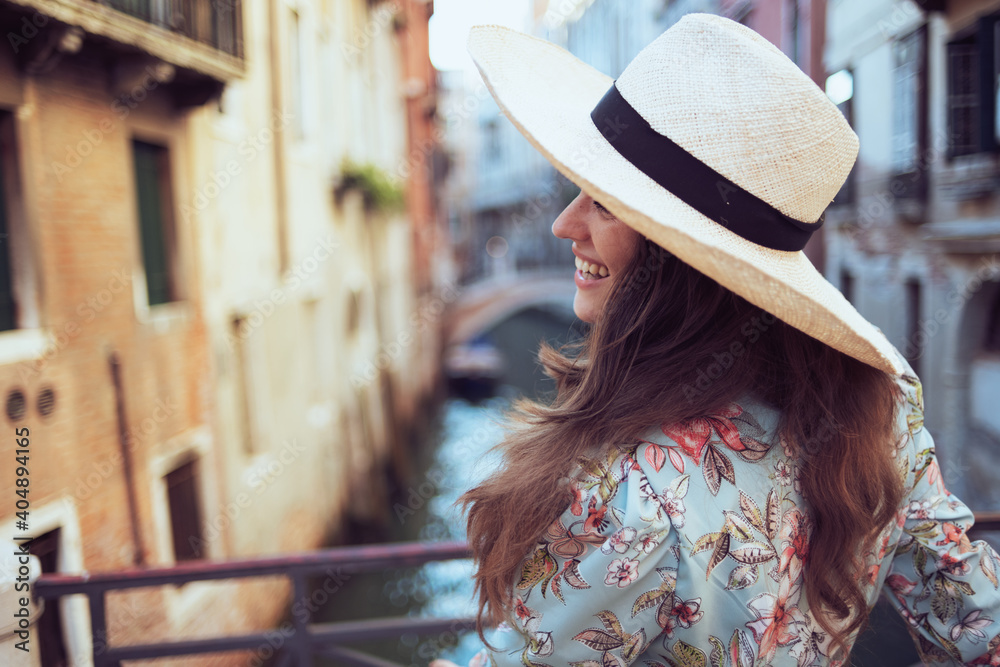 smiling solo traveller woman in floral dress sightseeing