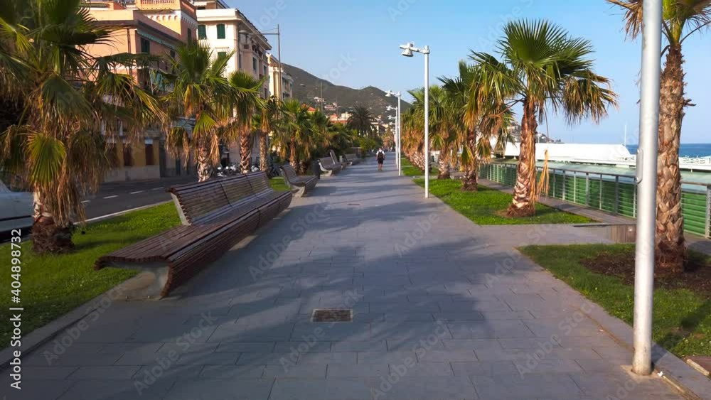 Varazze promenade at sunset with only one person walking alone Varazze promenade at sunset with only one person walking alone