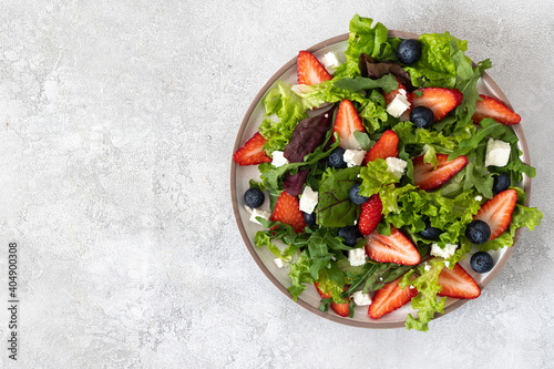 Fresh Strawberry, Blueberries salad with arugula,  feta cheese, olive oil, herbs. Healthy food.
