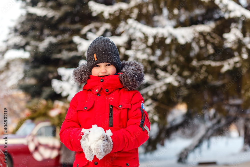 Boy in red jacket throws snow in winter Boy in red jacket throws snow in winter