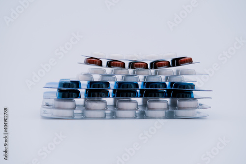 Stack of medicine pills in blister packs on white background. Medical treatment concept