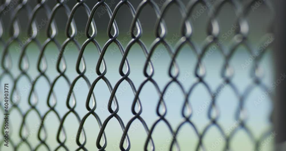 Close Up Soft Focus and Camera Rack on Chain Link Fence at Blue Tennis Court Close Up Soft Focus and Camera Rack on Chain Link Fence at Blue Tennis Court