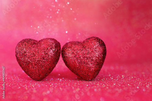 Valentine's day concept. Glitter red hearts over shiny background