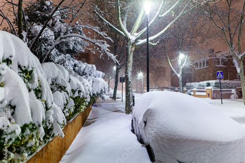 Cars and streets covered in snow in night image of Filomena storm fall in Madrid Spain.
 photo