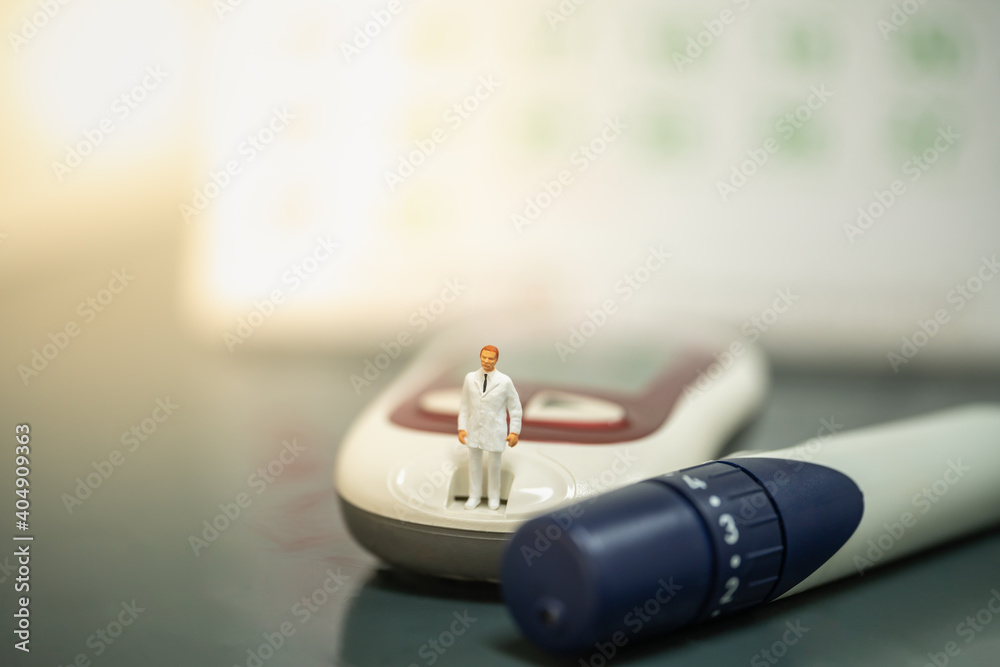 Docter miniature figure people standing on Glucose meter with lancet and calendar as background. Use as Medicine, diabetes, glycemia, health care and people concept. Docter miniature figure people standing on Glucose meter with lancet and calendar as background. Use as Medicine, diabetes, glycemia, health care and people concept.