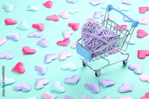 Colorful hearts with shopping cart on blue background