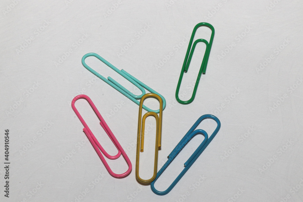 Paper clips. White background. Office supplies. Isolated colored paper clips on a white background Paper clips. White background. Office supplies. Isolated colored paper clips on a white background