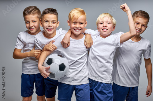 boys soccer team celebrating a victory after match, motivated children sports team rising hands up photo