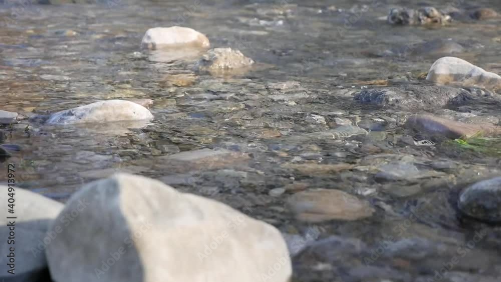 Small river with rocks. Water in a mountain stream flows around stones. Flowing between rocky shores. Close-up. Small river with rocks. Water in a mountain stream flows around stones. Flowing between rocky shores. Close-up.