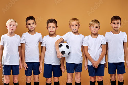 soccer team, kids in uniform posing at camera. friendly and strong gathered before match. studio portrait © Roman