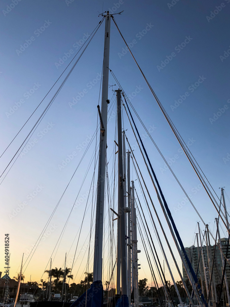 Obraz premium Sailboat masts against sunset