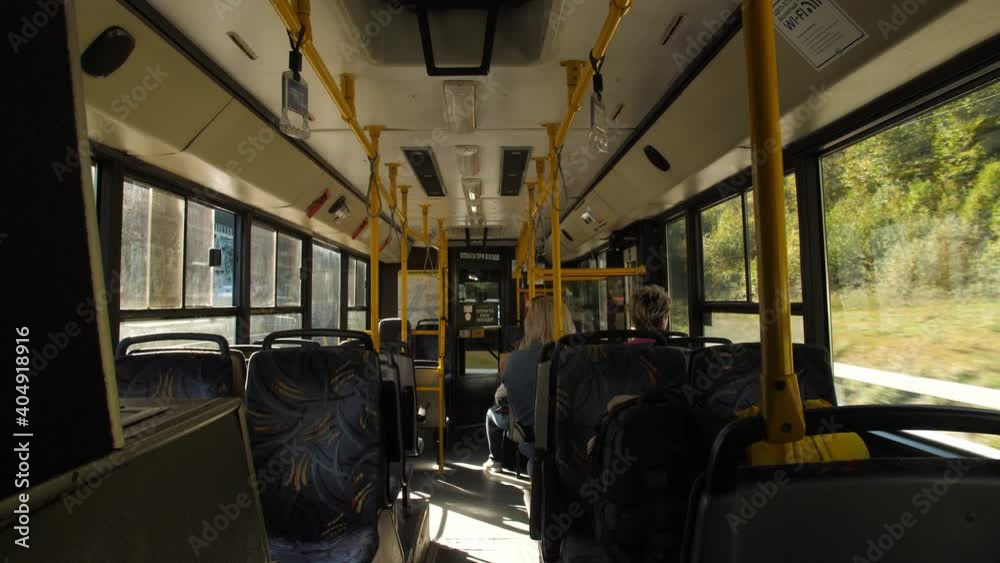a view of the interior of an intercity bus that travels at high speed along the highway entering a dark tunnel. people sit on the bus and endure the summer heat