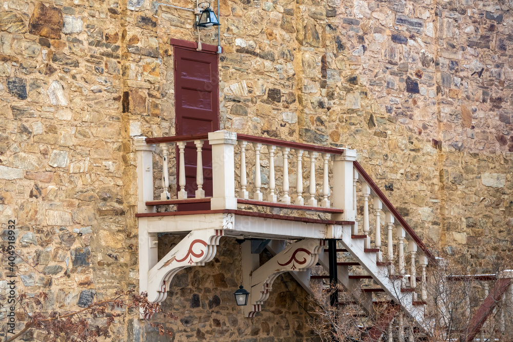 Φωτογραφία The wall of an old brick building with a door and beautiful wooden staircase in