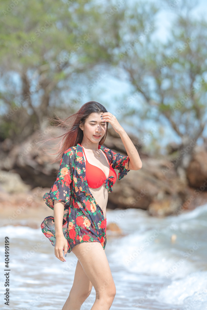 Cute young asian woman in bikini happy on beautiful beach in summer vacation in Thailand
