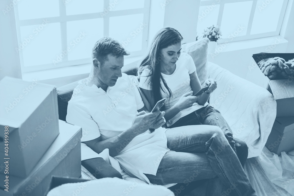 Obraz premium happy young couple looking at their smartphone screen .