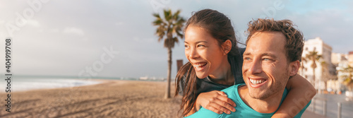 Happy couple having fun laughing on beach banner. Portrait of young Asian woman piggybacking on male boyfriend outside panoramic.