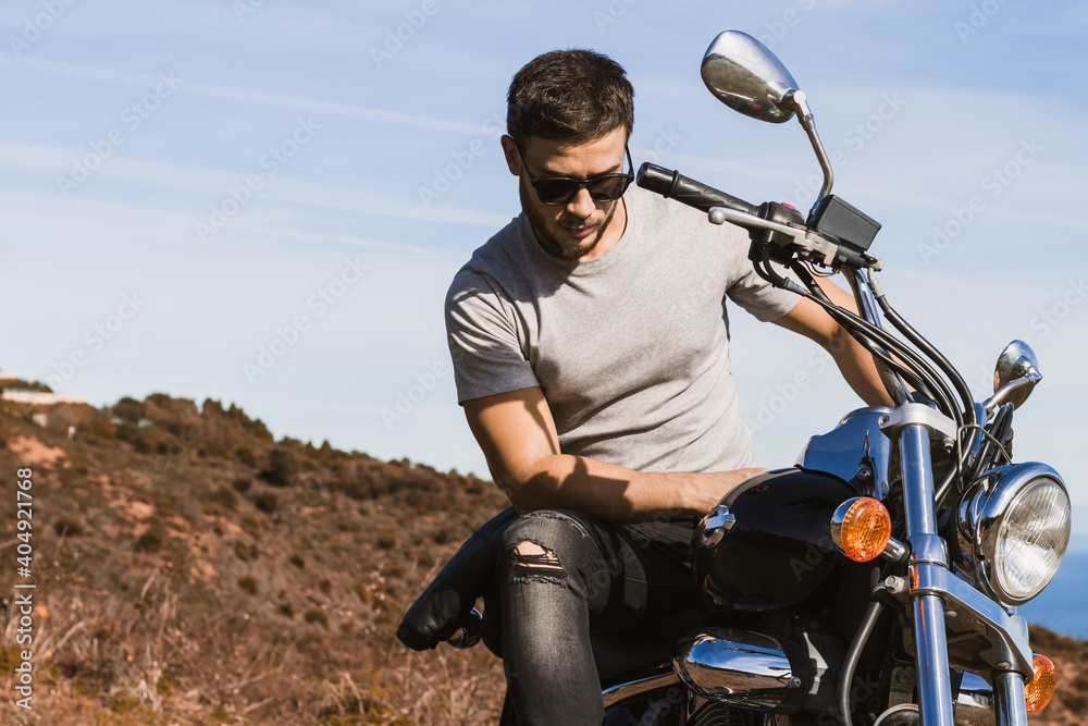 Horizontal partial view of young biker riding a custom motorcycle