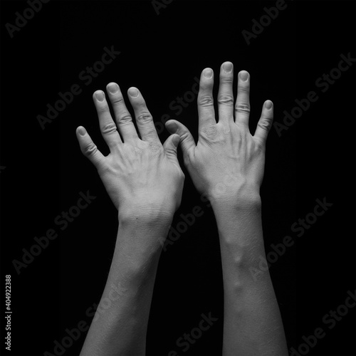 Black and white photo of female hands on a black background