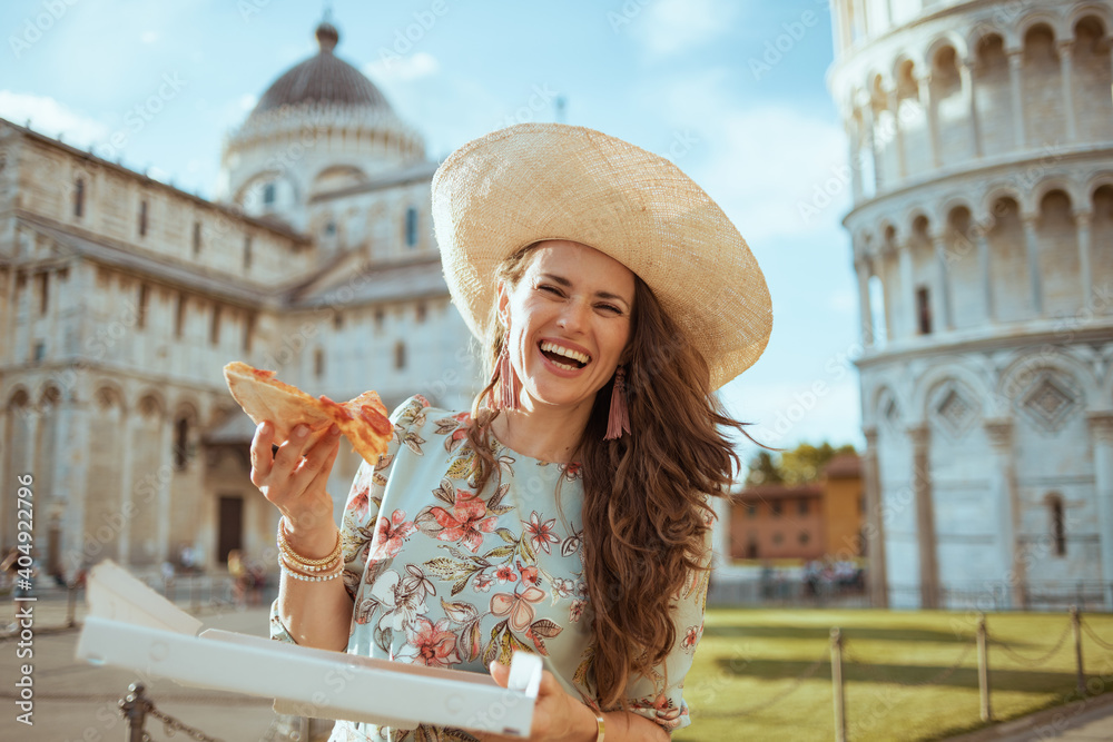 smiling elegant woman in floral dress with pizza and hat