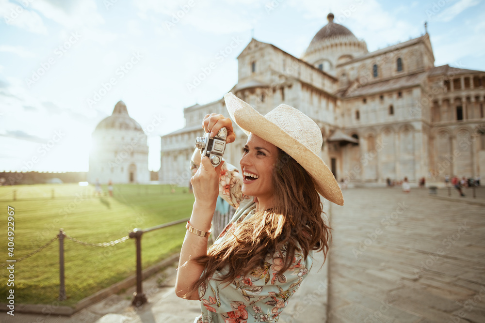 smiling trendy solo tourist woman in floral dress