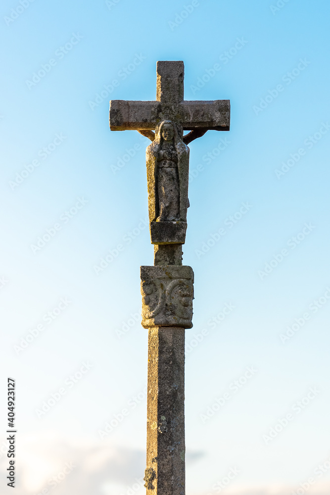old stone cross on a blue sky