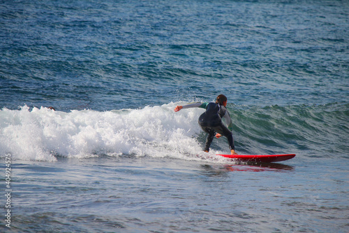 Photography Girl surfing in the waves of the Atlantic ocean (Tenerife, Canary Islands, Spain