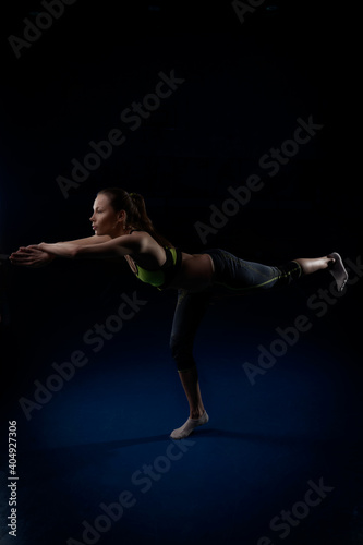 young woman doing yoga taking a position on one leg
