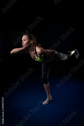 Yogi girl standing on one leg leaned forward and put her hands behind her back © Дмитрий Хитрин