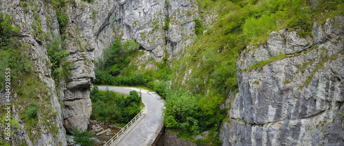 Aerial drone view of a bridge winding through the vertical stone walls of a sharp, steep canyon located in Sohodol Gorges. Carpathia, Romania.