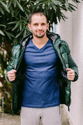 man wearing blue t-shirt mockup and jacket outdoors. Male in blank blue t-shirt v collar, front view outdoors. Design men t shirt template and mock-up for print 