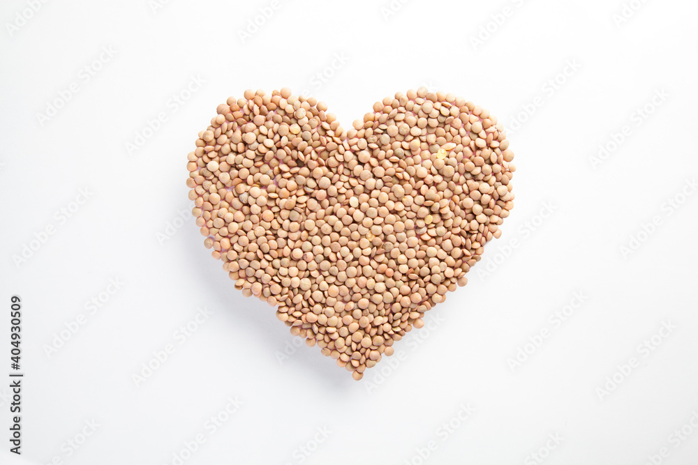 heart made of raw lentils on white background, healthy life and nutrition concept
