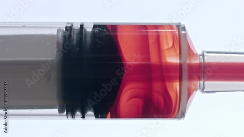 Clinical pharmaceutical trial closeup of vaccine solution in blood sucked into syringe tube