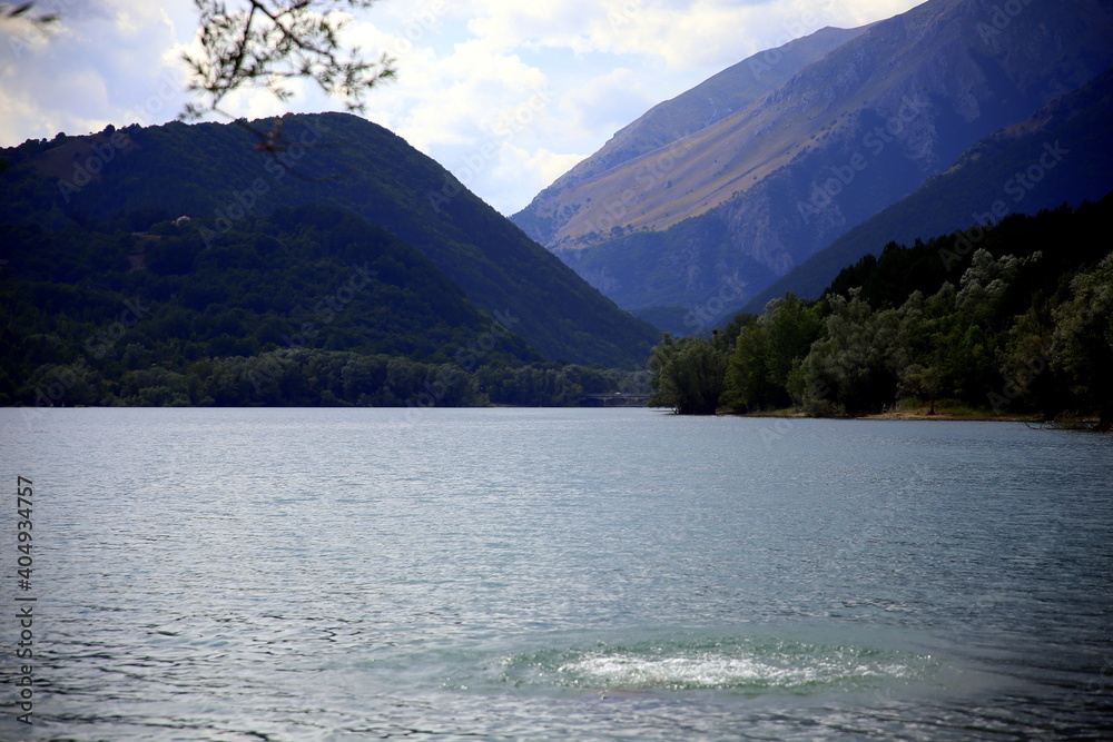 A dip in the lake among the green tree-lined mountains, Abruzzo region, Italy