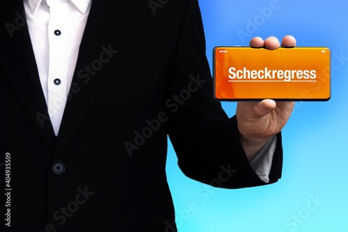 Scheckregress. Anwalt (Mann) zeigt ein Handy. Auf Display steht Text. Hintergrund blau. Hand hält Telefon. photo