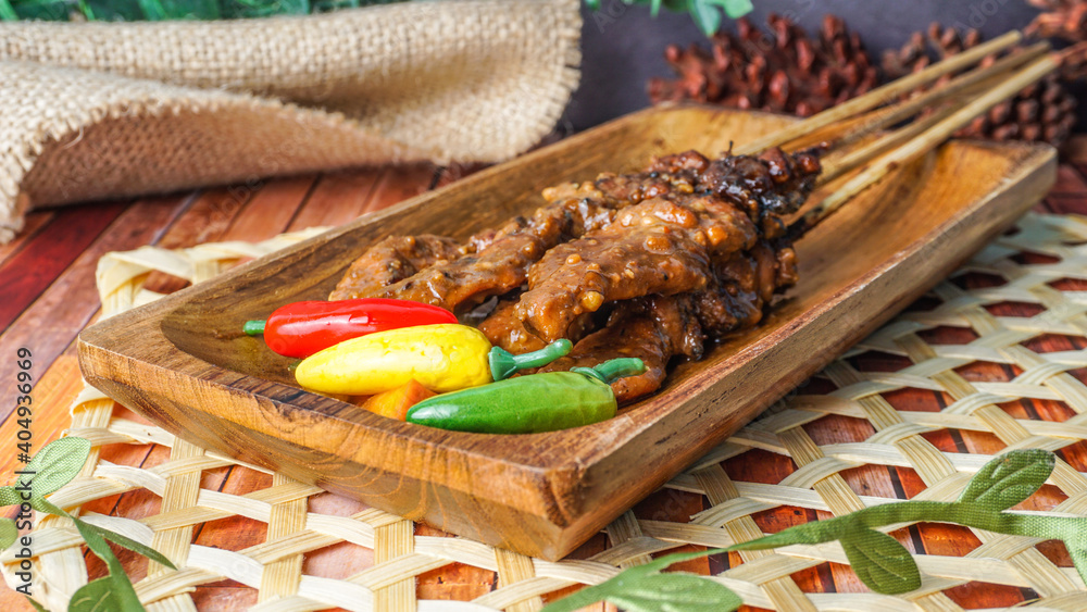 Selective focus - Barbecue chicken satay served on wooden plate