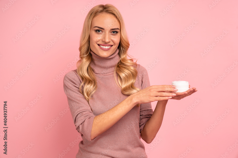 Portrait of adorable model having white jar with effective cream, applying under eyes, botox effect, fighting with dark circles, looking at camera isolated on pink background. Portrait of adorable model having white jar with effective cream, applying under eyes, botox effect, fighting with dark circles, looking at camera isolated on pink background.