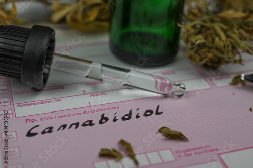 Macro close up of cannabidiol oil panel prescription form with bottle, pipette and dried cannabis leaves photo